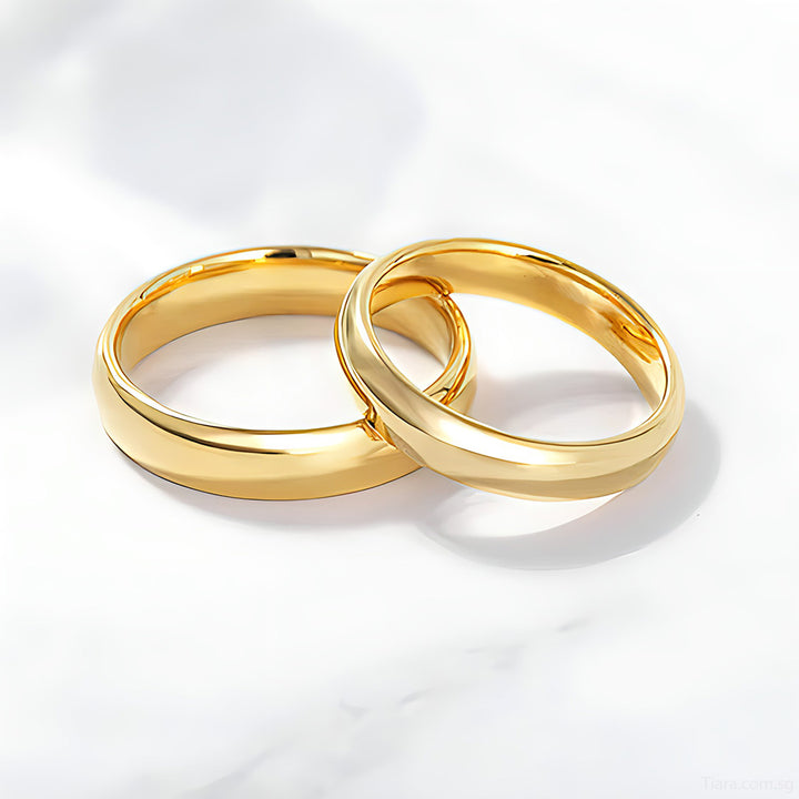 A luxurious arrangement of various gold rings, wedding bands, and couple's rings elegantly displayed on a soft velvet surface, with a blurred background enhancing their beauty.